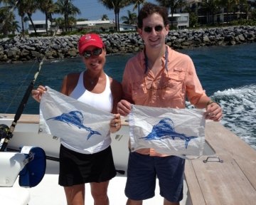 Couple holding up blue marlin flags